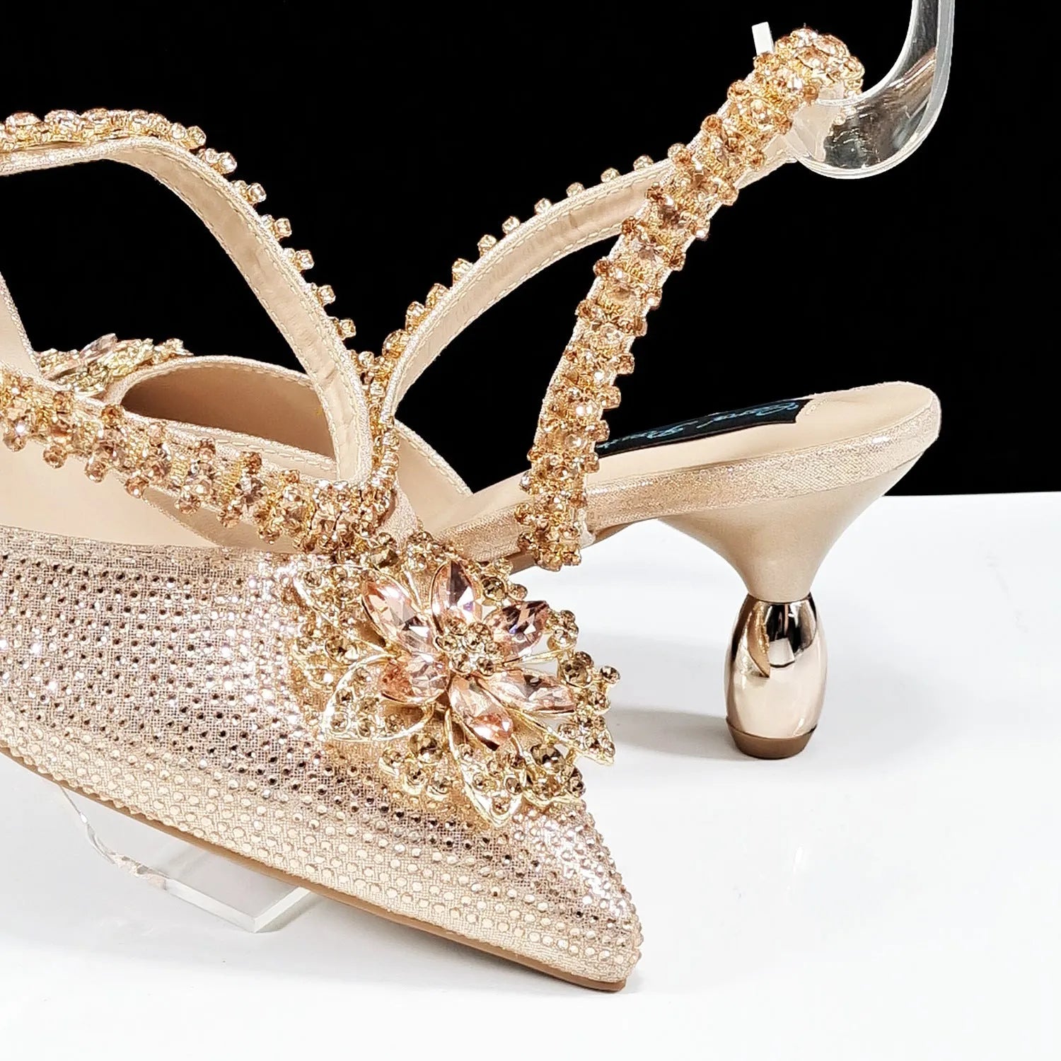 Women's black high-heel shoes with decorative ankle chain featuring floral rhinestone accents and matching clutch bag
