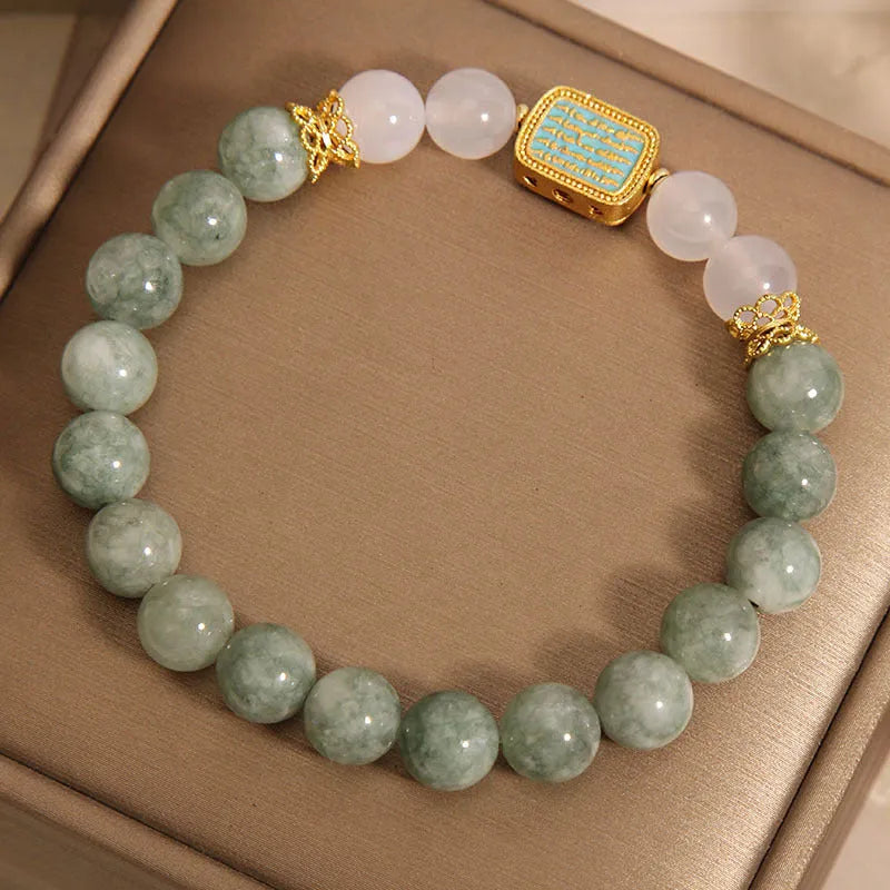 Natural oil green emerald crystal bracelet with five beads on a black elastic cord.