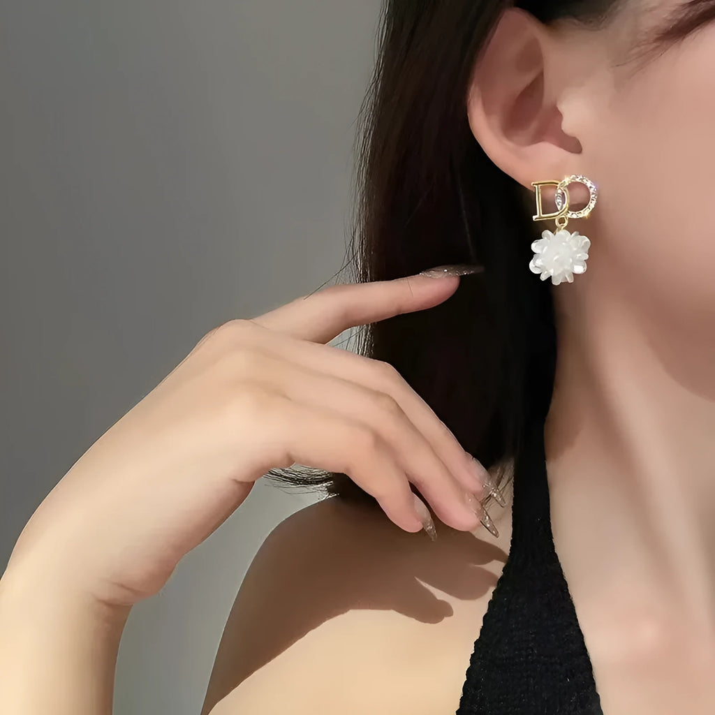 White DO letter embroidered ball earrings for women, trendy drop style with letter and ball detail.