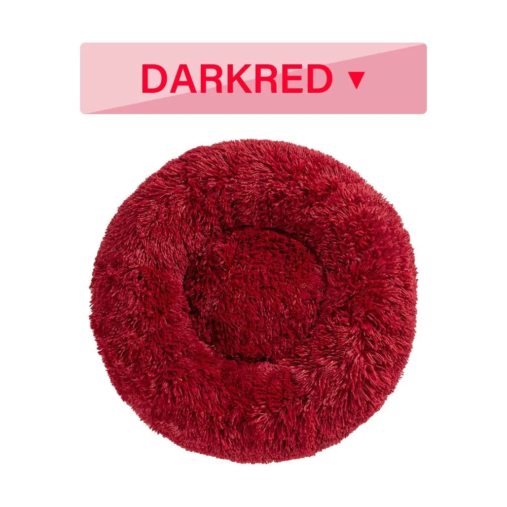 Fluffy donut-shaped dog bed in long plush fabric, shown in a light grey colour with a raised bolster edge.