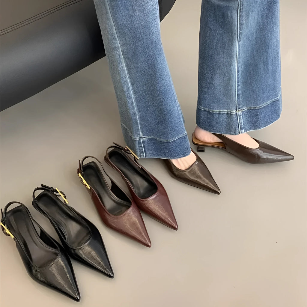 Women's black leather pointed toe shoes with a thin ankle strap and a low block heel.