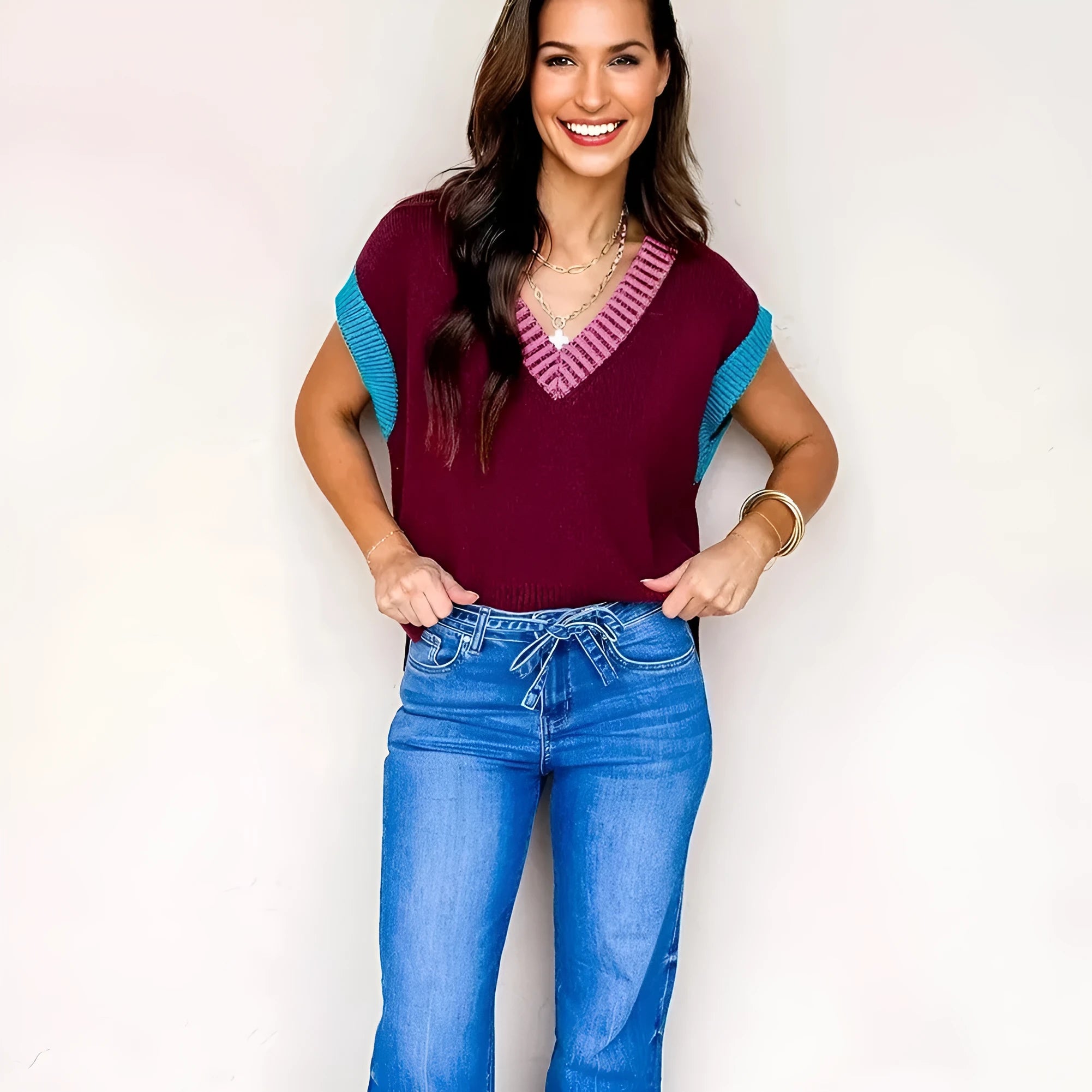 Burgundy loose V-neck sweater with cuffed short sleeves and light contrast trim laid flat.