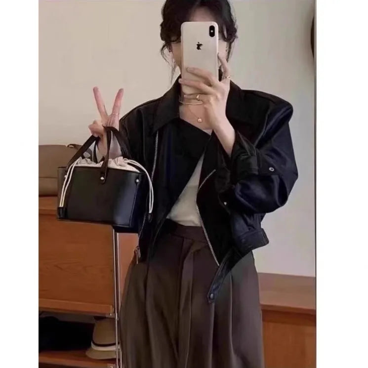 Brown women's retro slim-fit imitation leather jacket with a pocket on a hanger.