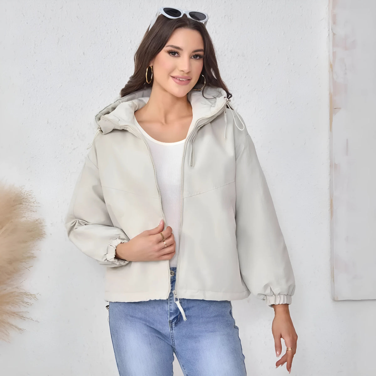 Women's loose-fit hooded shell jacket in grey shown from the front, with long sleeves and a zip front.