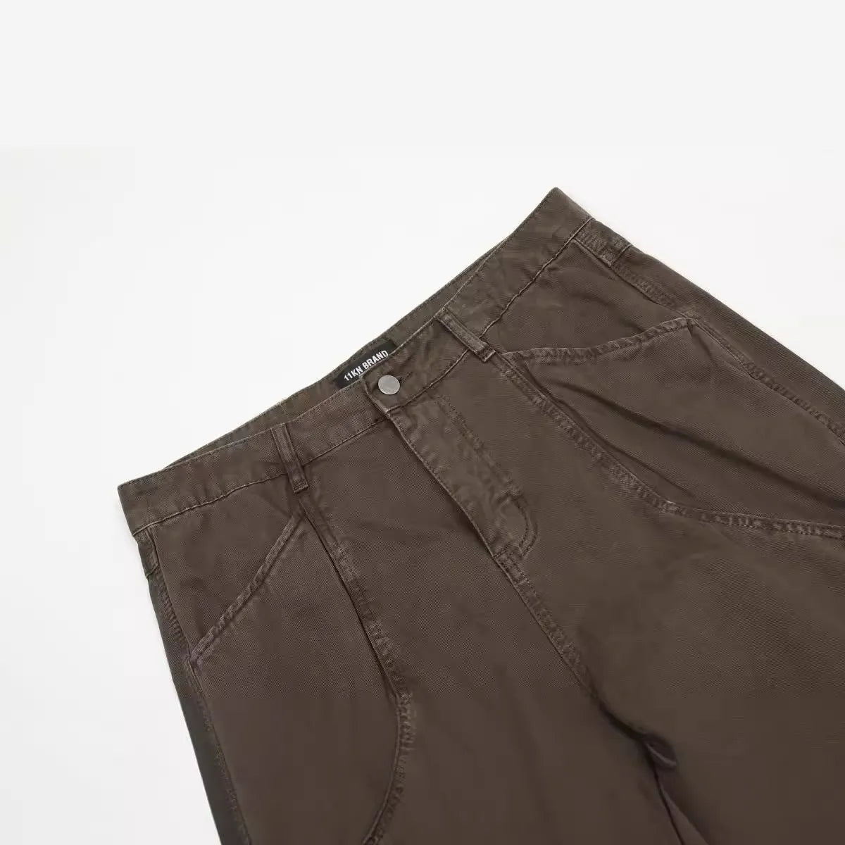 Men's brown straight-leg trousers with high waist and non-ironing cotton fabric on a hanger