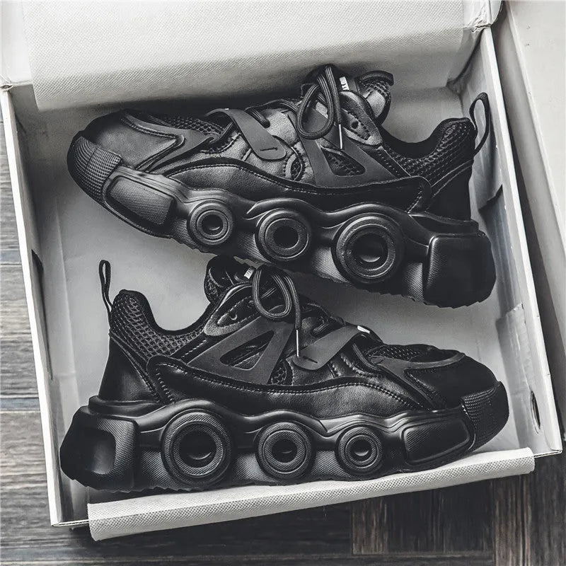 Men's black casual sneaker with thick rubber sole, mesh upper, abstract pattern, and lace-up front.