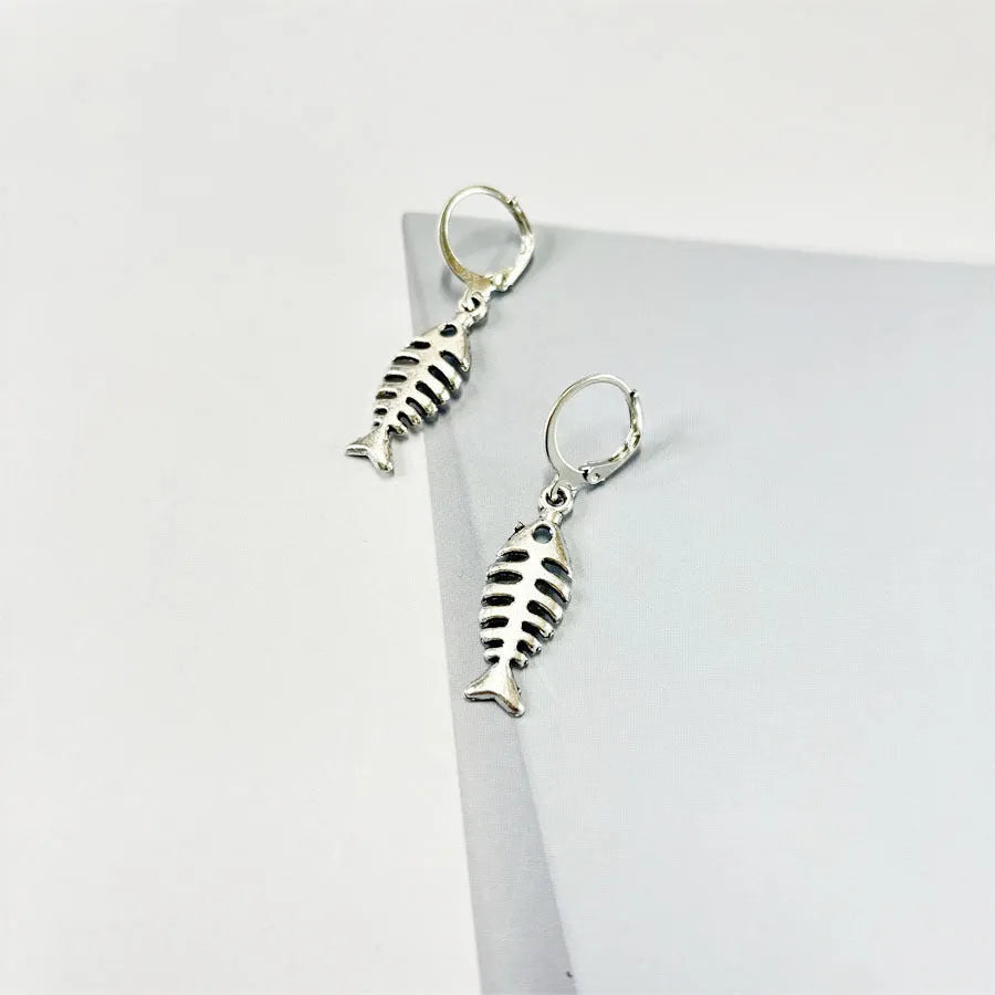 Fishbone pendant necklace with adjustable chain and matching retro earrings set on dark background