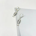 Fishbone pendant necklace with adjustable chain and matching retro earrings set on dark background