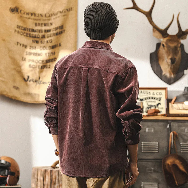 Men's red corduroy shirt jacket with loose fit design and long sleeves on hanger