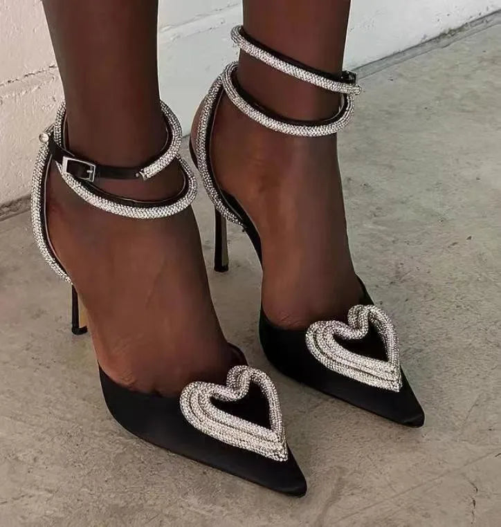 Women's pink satin sandals with pointed toe, heart-shaped rhinestones, and 9.5cm heel on a rubber sole.