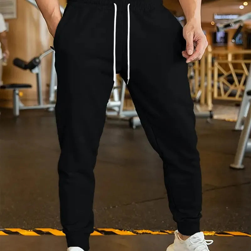 Men's beige loose-fit leisure trousers with an elastic drawstring waist and a thin 3D pattern fabric.