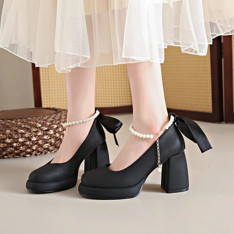 Beige women's Mary Jane shoes with a chunky heel, round toe, and pearl-decorated ankle strap buckle on a white background.