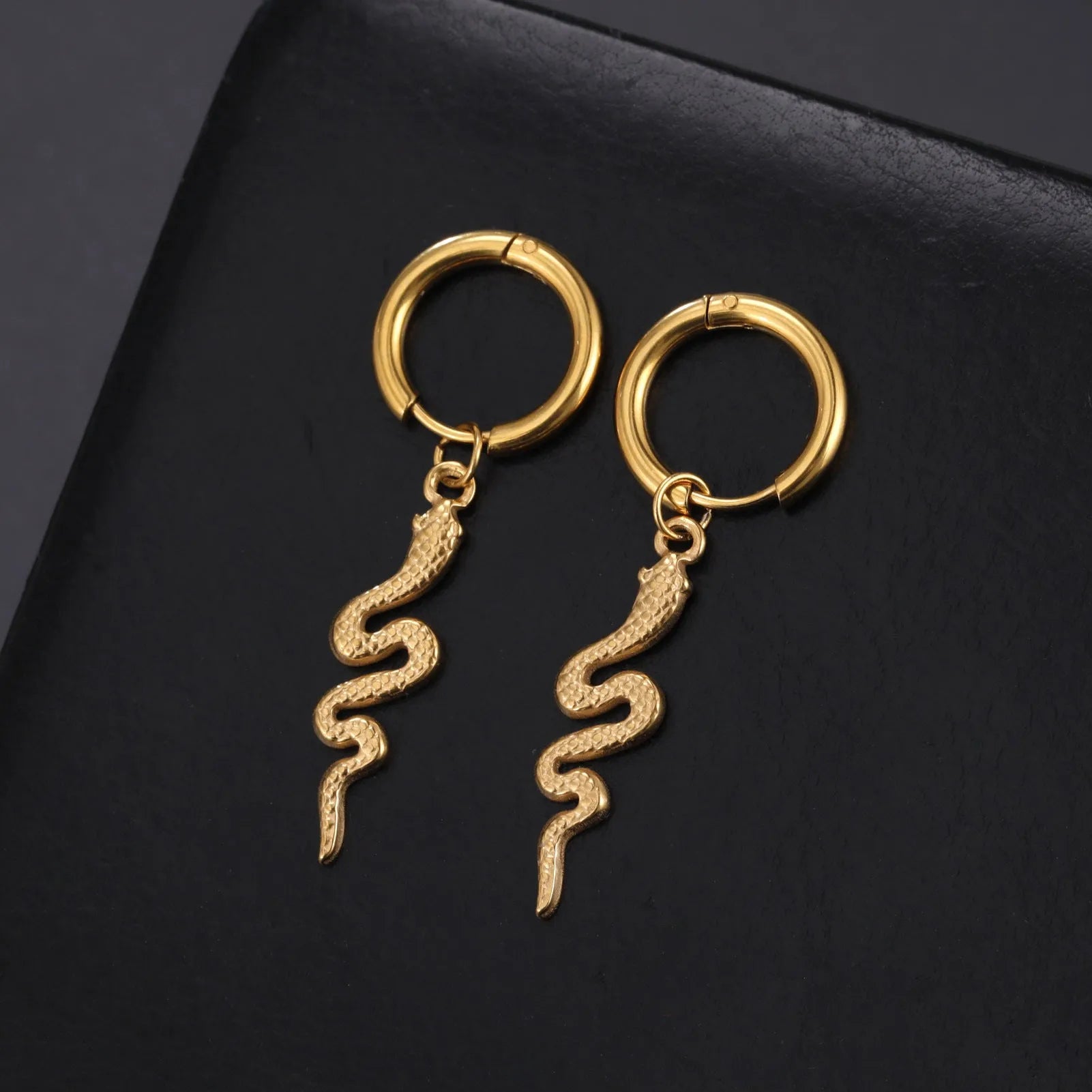 Gold plated stainless steel snake-shaped vintage earrings with detailed scale patterning and clip back closure