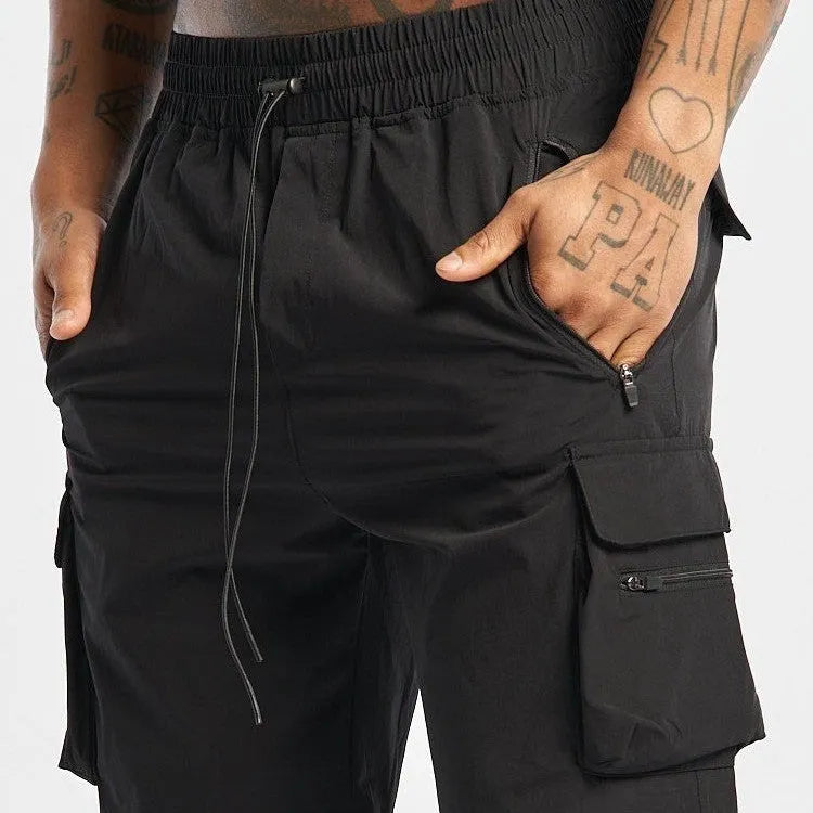 Men's black quick-dry sports shorts with four-sided stretch, shown on a model for running and fitness.