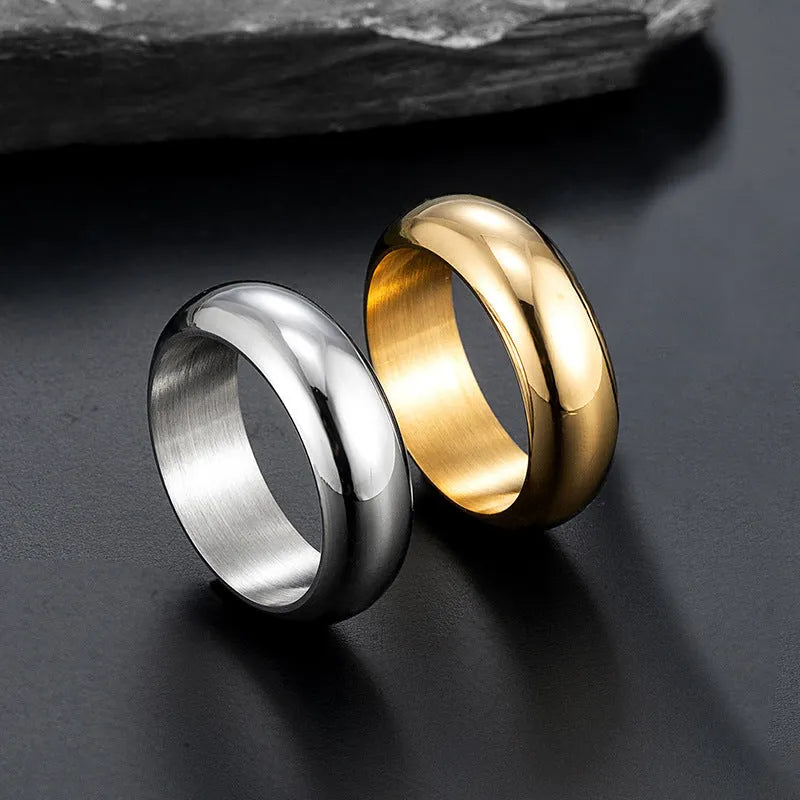 Glossy electroplated titanium steel ring in gold, black, and steel colour options on a grey background
