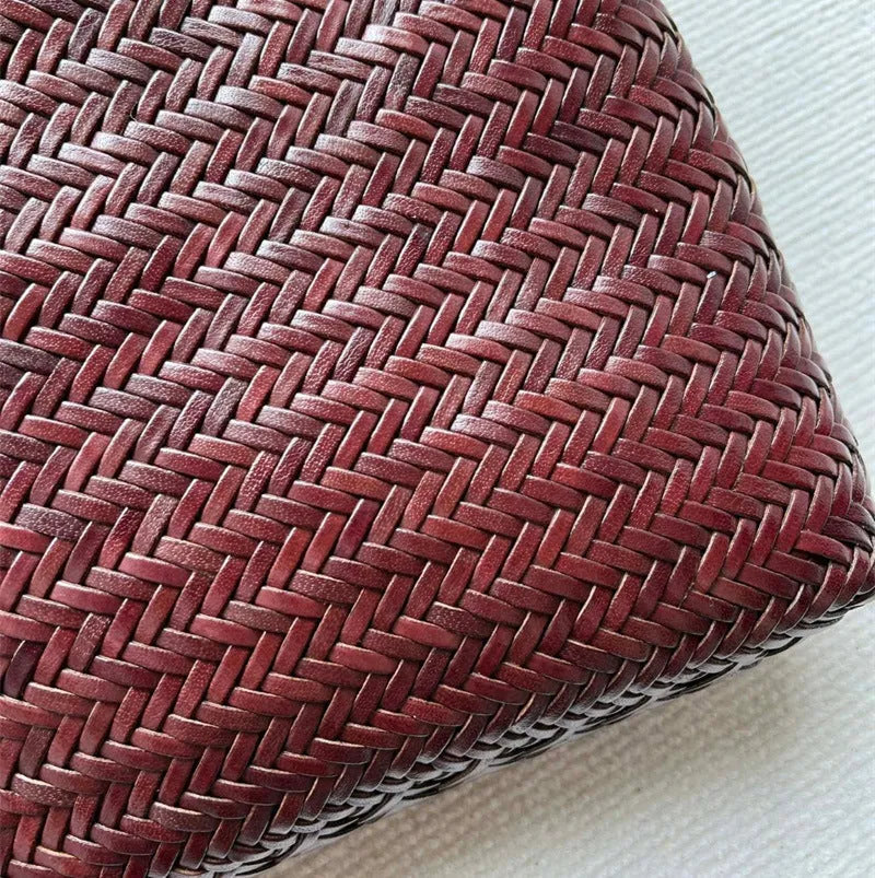 Brown woven leather tote bag with three-dimensional pocket, showing 27x30x6cm dimensions and handmade construction