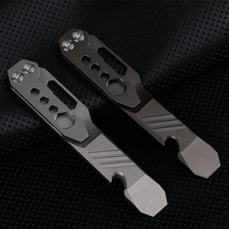 Titanium multi-function crowbar tool with screwdriver tip and bottle opener, shown in stone wash and gun grey finishes.