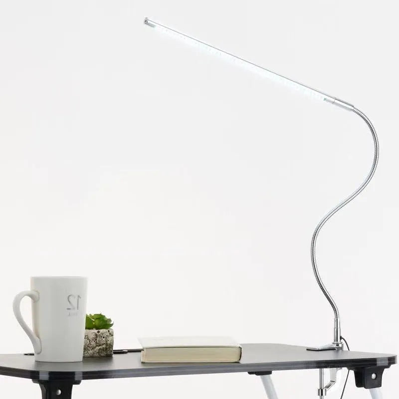 Silver aluminium alloy USB LED nail lamp with long arm and clip-on base, lit with bright white light.