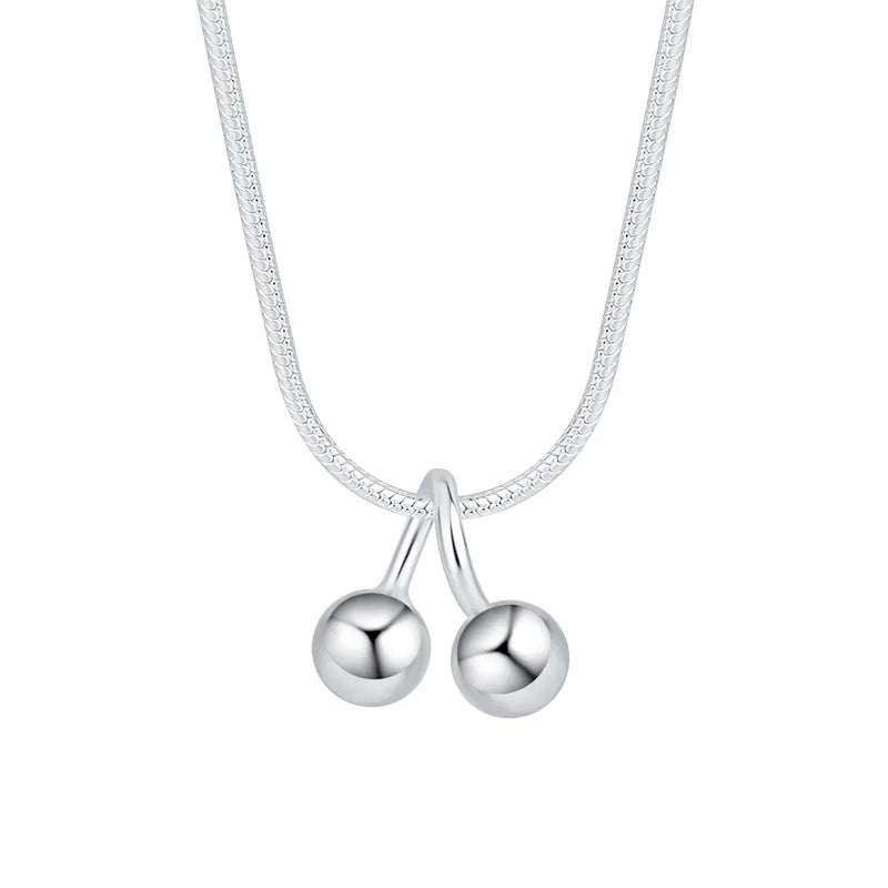 Silver cherry necklace with adjustable snake bone chain and detailed fruit pendant on a model