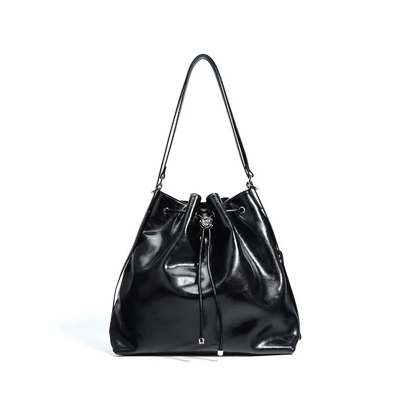 Genuine leather one-shoulder bucket bag in brown showing interior file compartment and zippered pockets