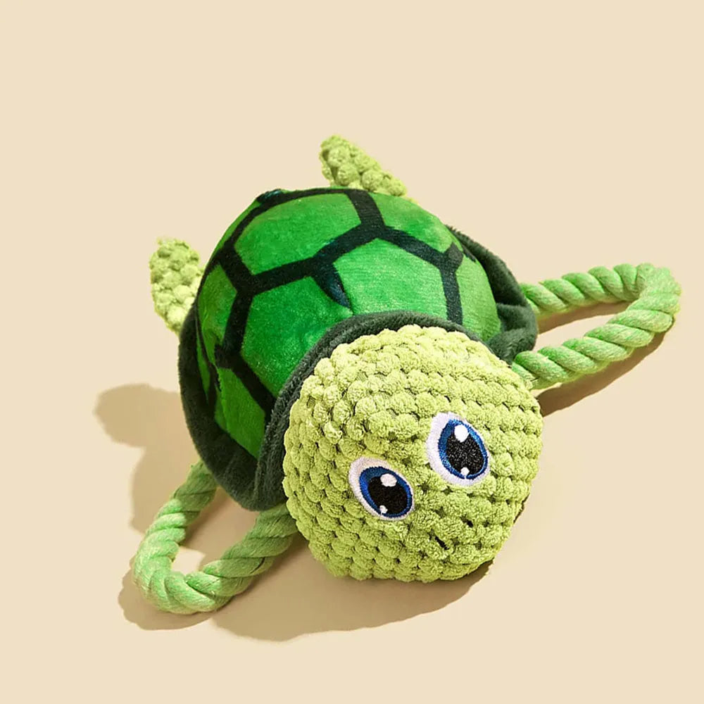 Grey, green, and orange turtle-shaped plush dog chew toy with knotted body.