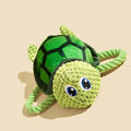 Grey, green, and orange turtle-shaped plush dog chew toy with knotted body.