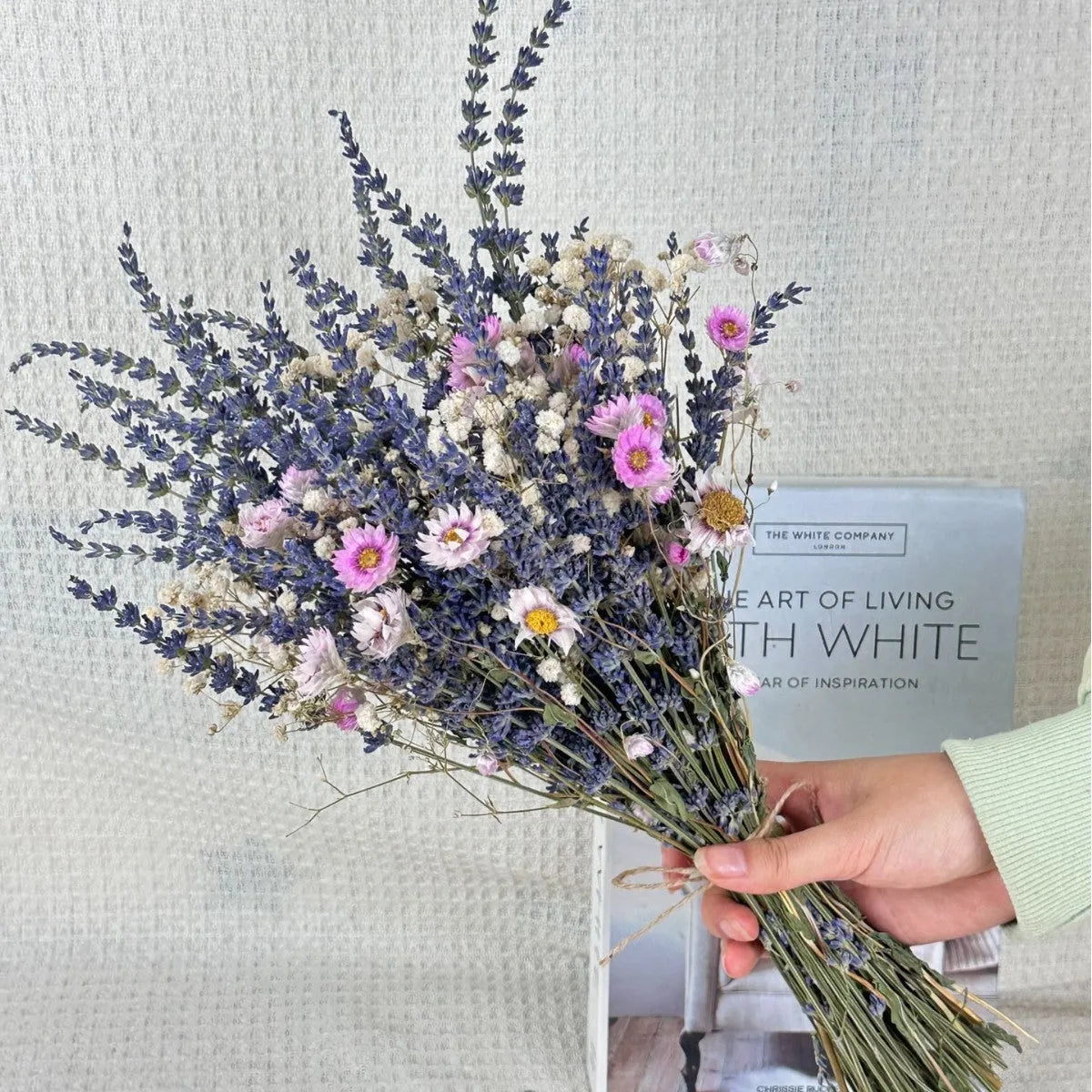 A long dried lavender flower bouquet in a vase, showing white or pink colour options.