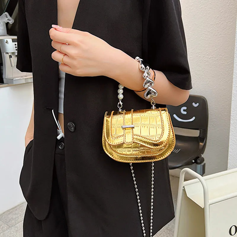 Laser Pearl Tote Saddle Girl Mini crossbody bag in gold colour showing horizontal square design and shoulder strap