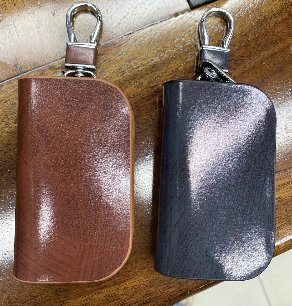 Black or brown genuine leather car key case with zipper, showing soft cowhide texture and internal size of 9.5cm by 4.5cm