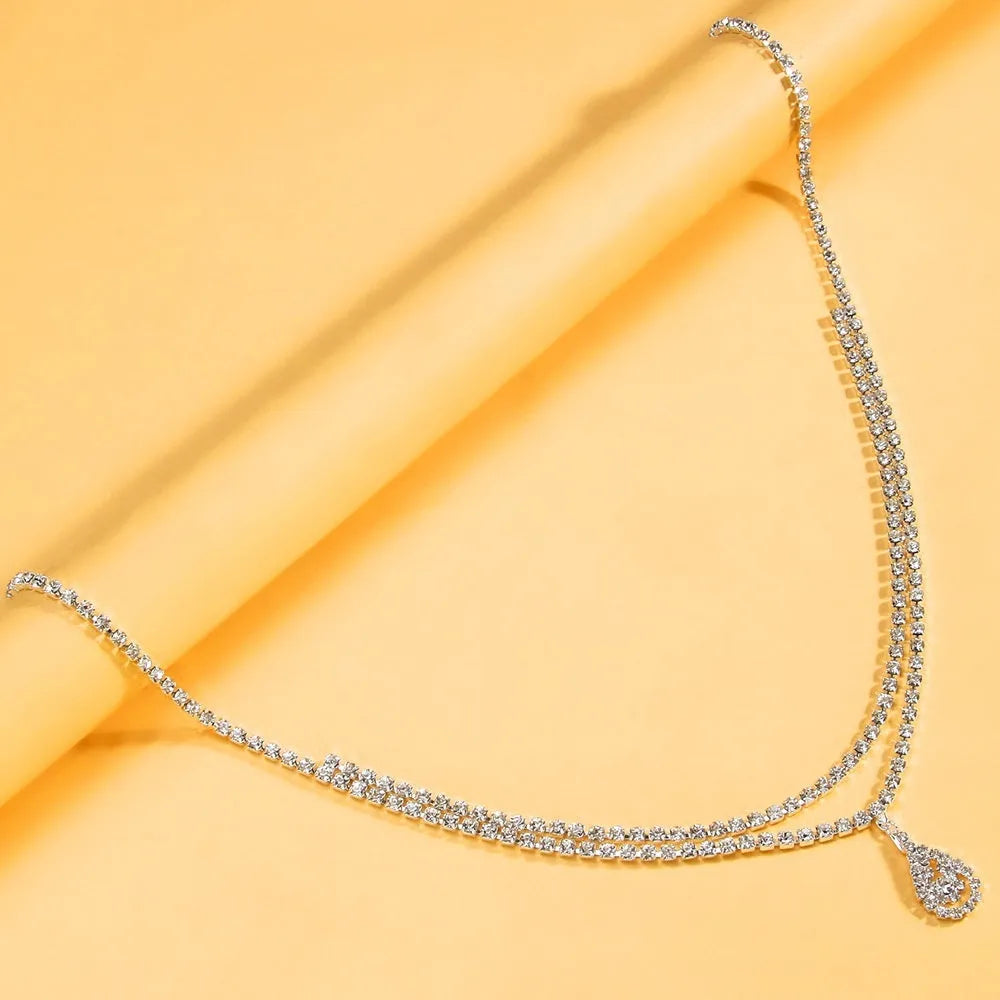 Gold adjustable waist chain with rhinestone water drop pendant and lobster clasp on mannequin