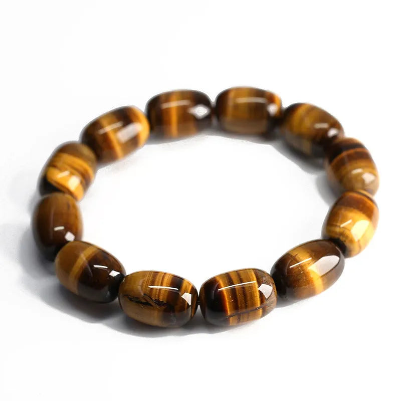 Close-up of a natural yellow Tiger Eye gemstone beaded bracelet with cat's eye effect on a wrist.