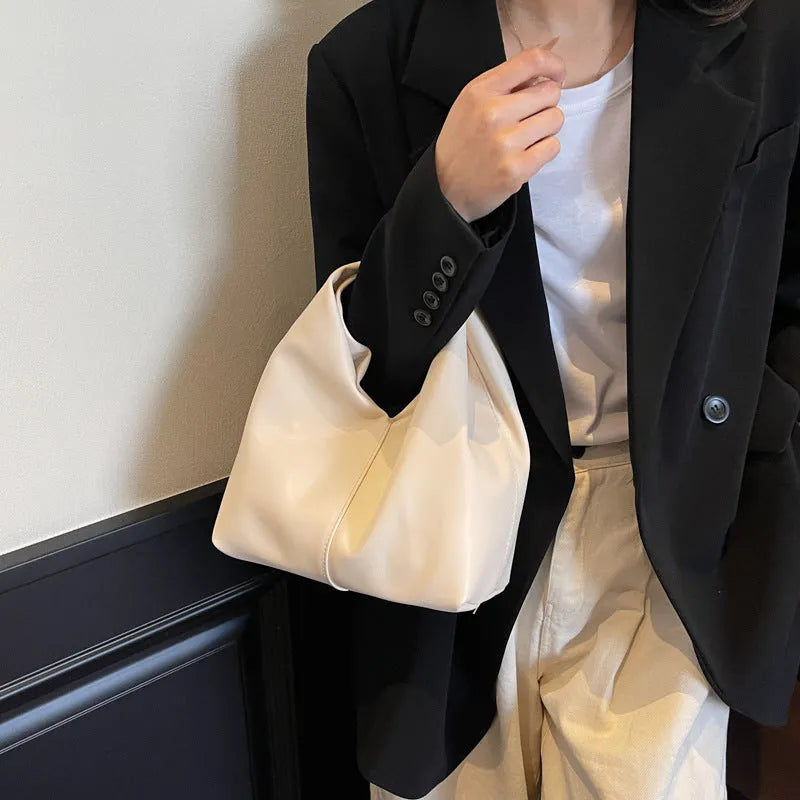 Dumpling-shaped women's handbag in various colours showing sandwich pocket design and fold-stitch details