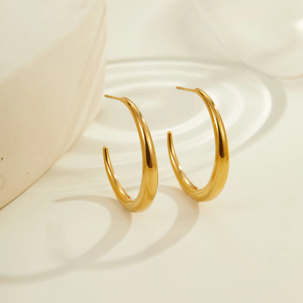 Gold and steel coloured titanium steel hoop earrings for women in large and small sizes.