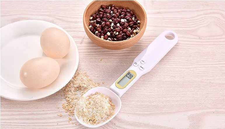 Black electronic measuring spoon scale showing digital display with 0.1g precision for kitchen weighing