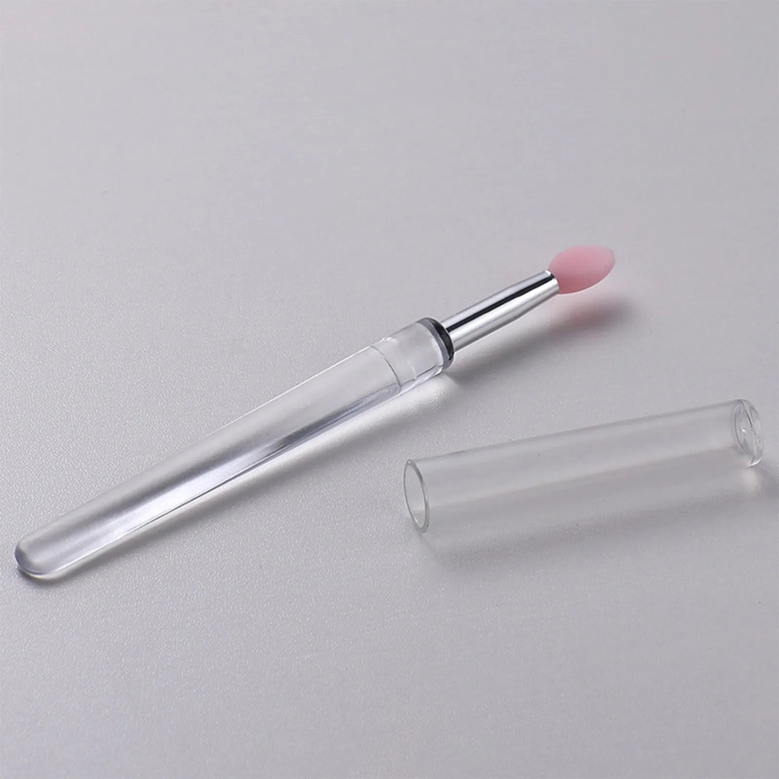 Set of reusable silicone lip brushes with caps in eight different colours on a white background.