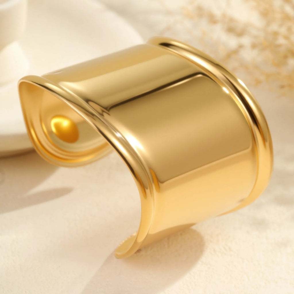 Gold plated wide women's bracelet with asymmetric geometric design and a niche opening.