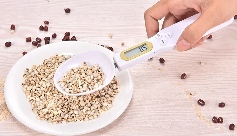 Black electronic measuring spoon scale showing digital display with 0.1g precision for kitchen weighing