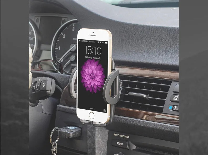 Black plastic mobile phone holder attached to car air conditioning vent with phone secured