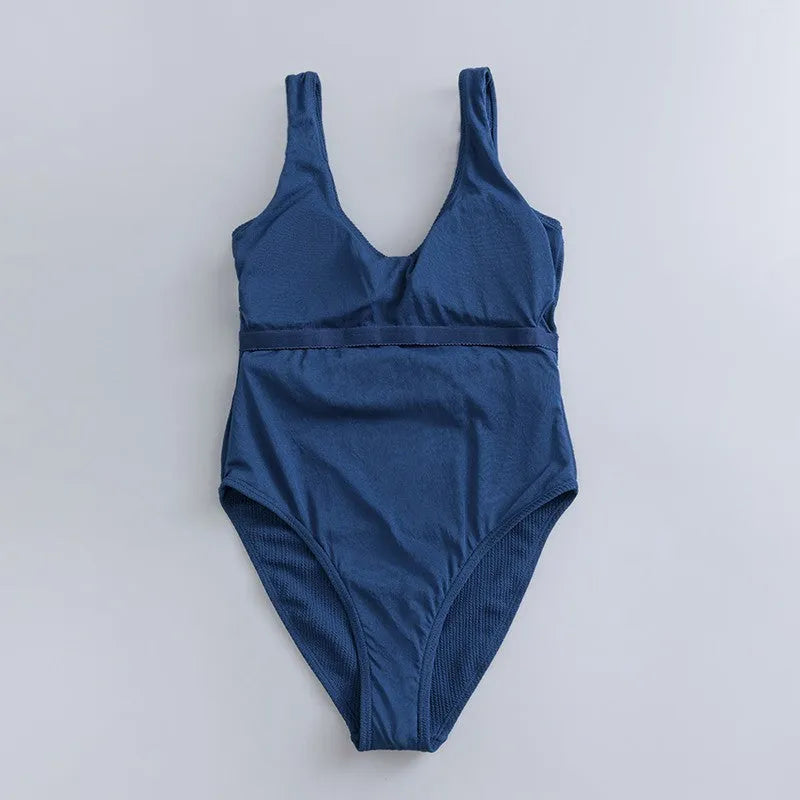Women's navy blue one-piece swimsuit with triangle neckline and built-in chest padding