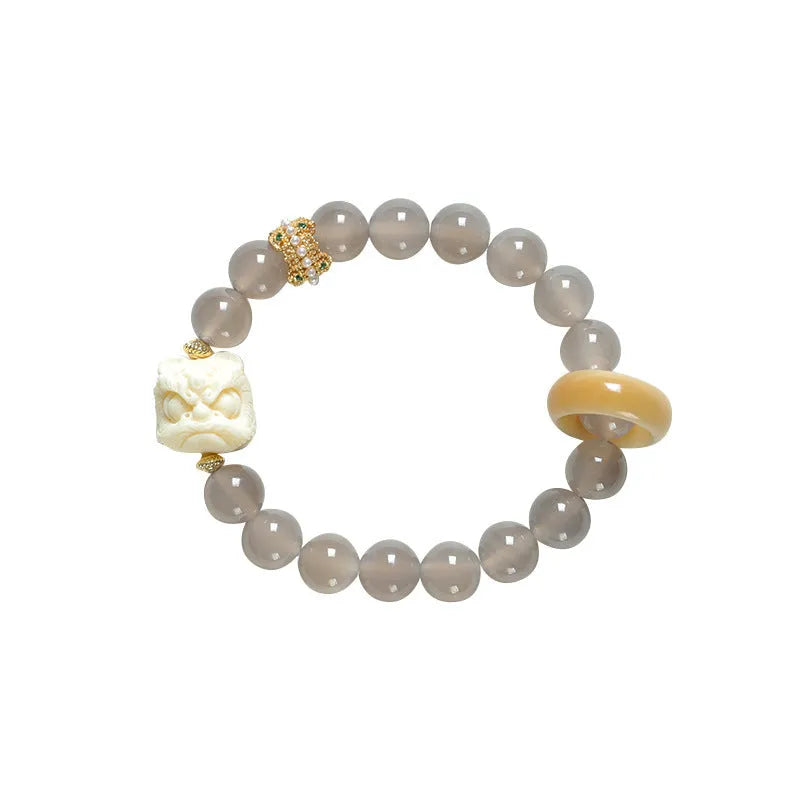 Hand-woven bracelet with round grey agate and mellite beads on a white background.