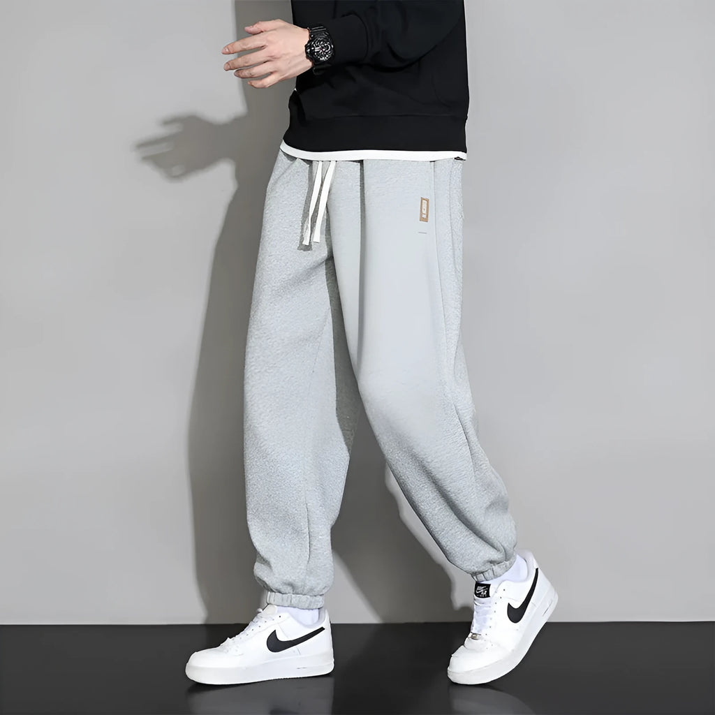 Men's loose grey cotton sports trousers with elastic waistband on hanger