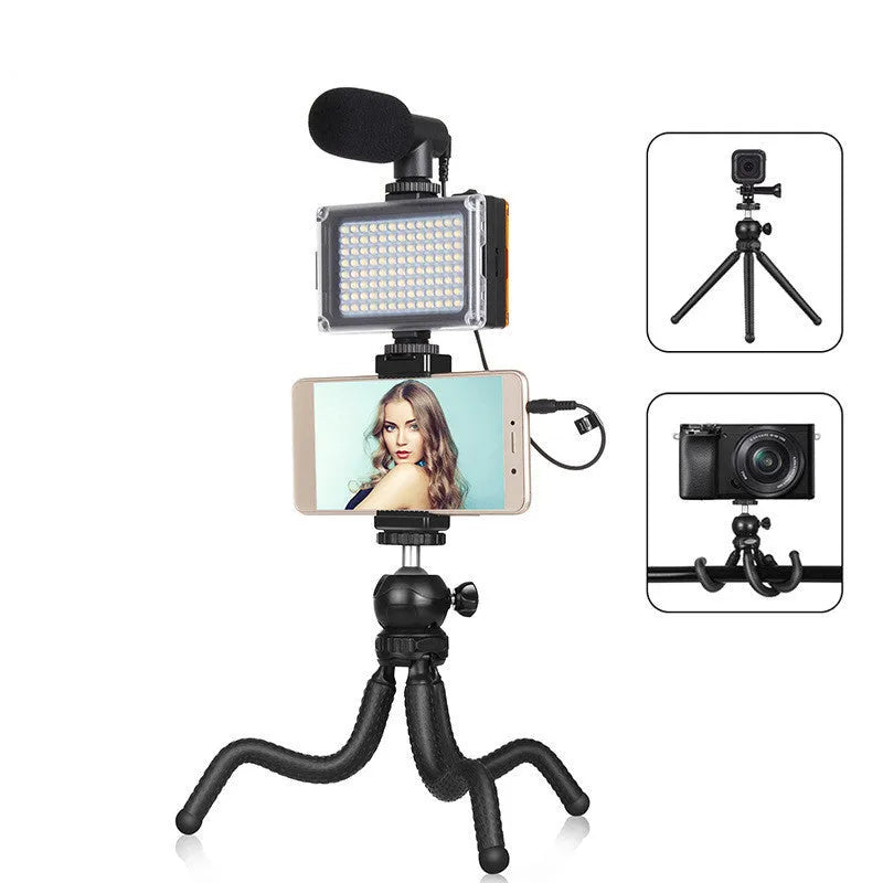 Black octopus tripod with flexible legs wrapped around a lamppost, showing 360-degree ballhead and fill light microphone attached to an iPhone.