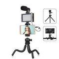 Black octopus tripod with flexible legs wrapped around a lamppost, showing 360-degree ballhead and fill light microphone attached to an iPhone.