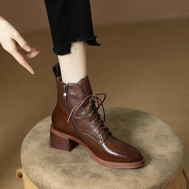 Women's black pointed-toe ankle boots with a short shaft and a low heel on a plain background.
