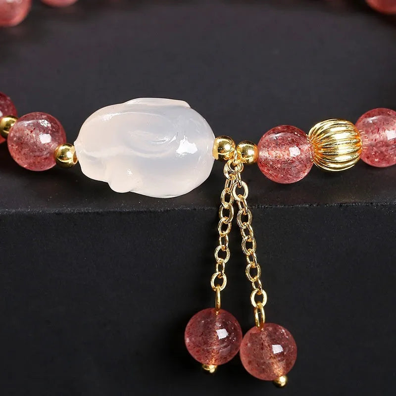 Handcrafted women's bracelet with strawberry quartz and agate beads featuring a white rabbit design.