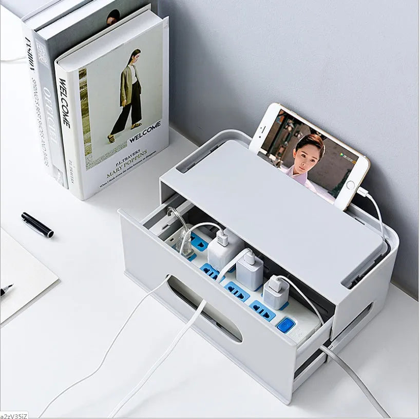 White plastic wireless router storage box mounted on a wall with cables routed through internal channels.