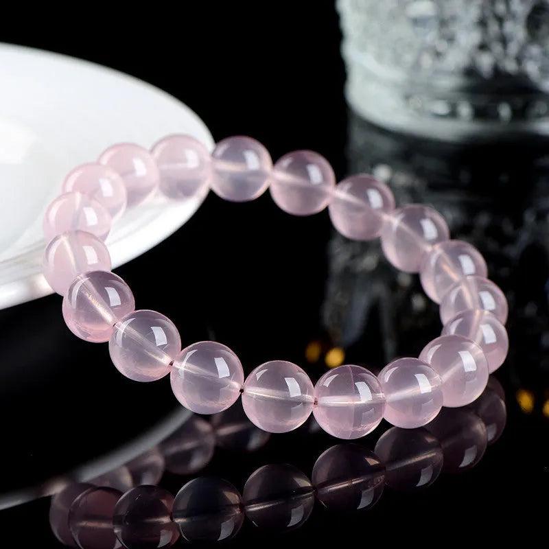 Natural crystal round beads bracelet with hand-polished finish in pink colour, showing seven size options from 6mm to 22mm diameter