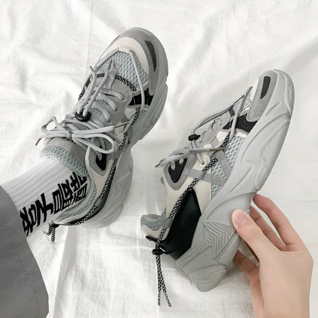 Men's white platform trainers with lace-up front and a breathable mesh lining, shown from the side.