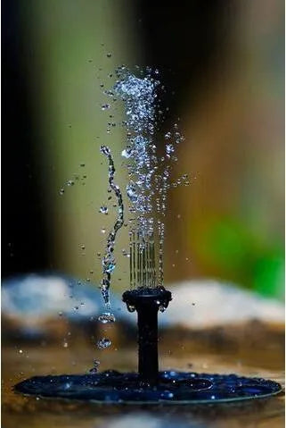 Black solar floating fountain with 4 nozzle attachments in garden pond setting