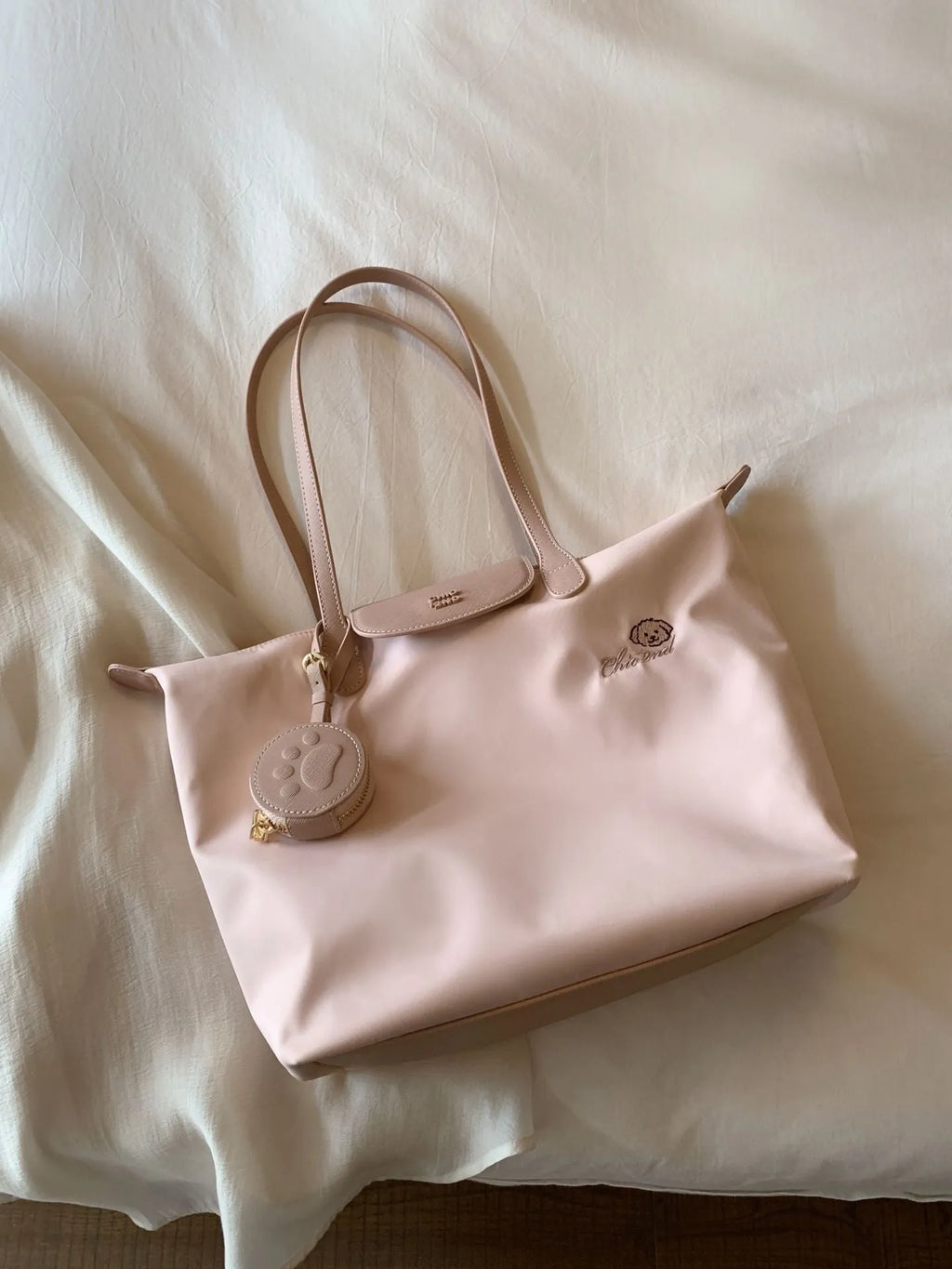 Pink Oxford cloth tote bag with sandwich pocket and shoulder strap showing sewing thread detailing